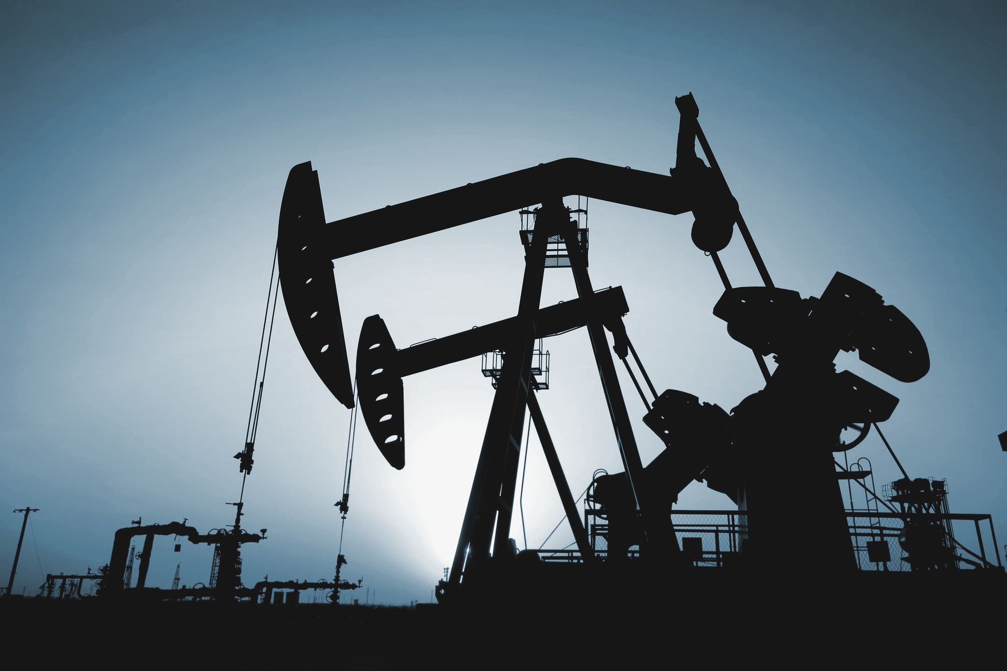 Pumpjacks silhouetted against a low sun